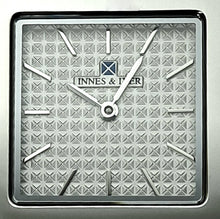 Square watch's clock face with hands in silver colour.