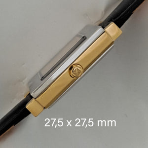 Square watch's crown side with gold colour case and silver colour front 27,5 x 27,5 mm.