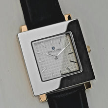 Square watch's front with gold colour case and silver colour front 33 x 33 mm.