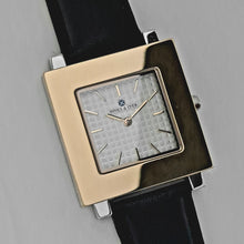 Square watch's  front with silver colour case and gold colour front 33 x 33 mm.